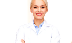 Eine lächelnde Person in einem weißen Kittel mit verschränkten Armen.