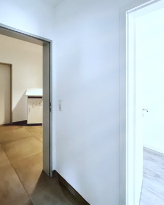 lichter flur im hellen und schlichten praxis ambiente mit akten tischchen