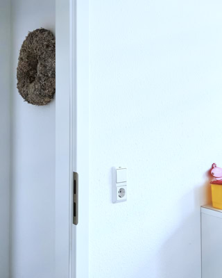 weitlaeufig wirkender blick von einem behandlungsraum ueber den flur zum naechsten praxiszimmer aus stafiert mit unaufdringlicher dekoration