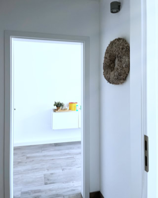 weisse tuerrahmen, waende und moebel garniert mit wenigen farbigen akzenten laden zum verweilen ein